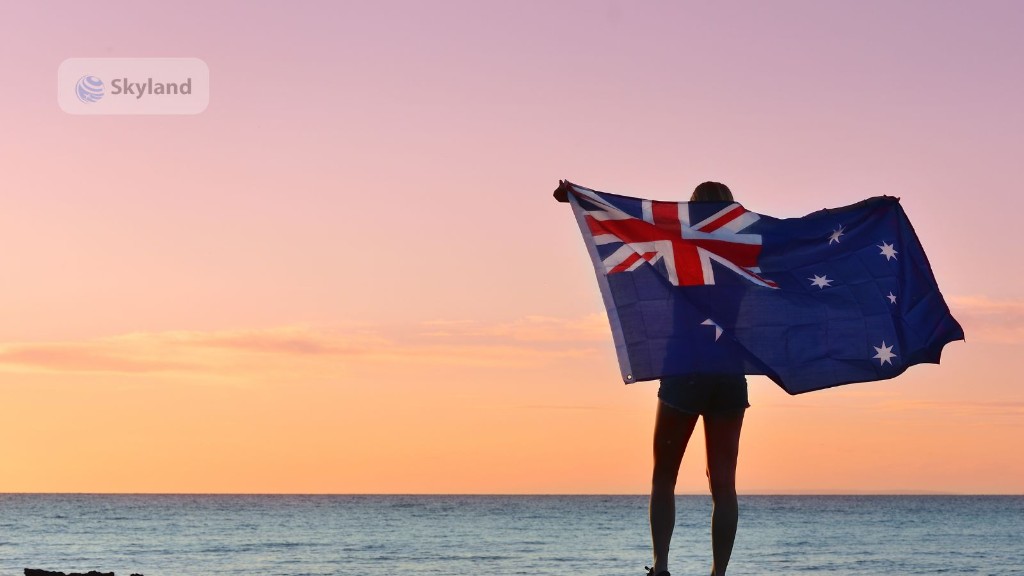 Person holding the Australian flag on a beach at sunset