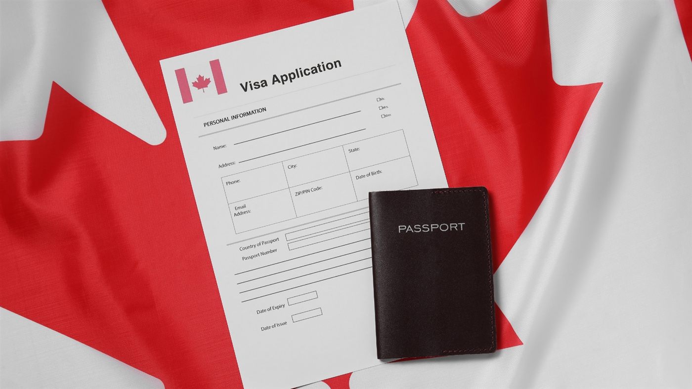 Visa application form and Canadian passport on the Canadian flag