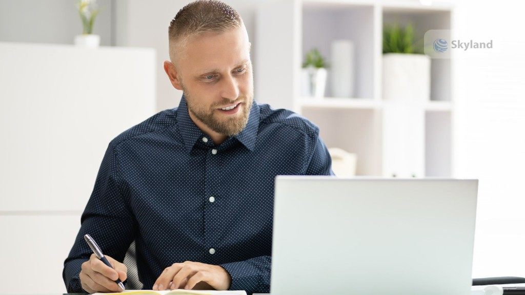 A professional studying with a laptop and notebook for IELTS General Training