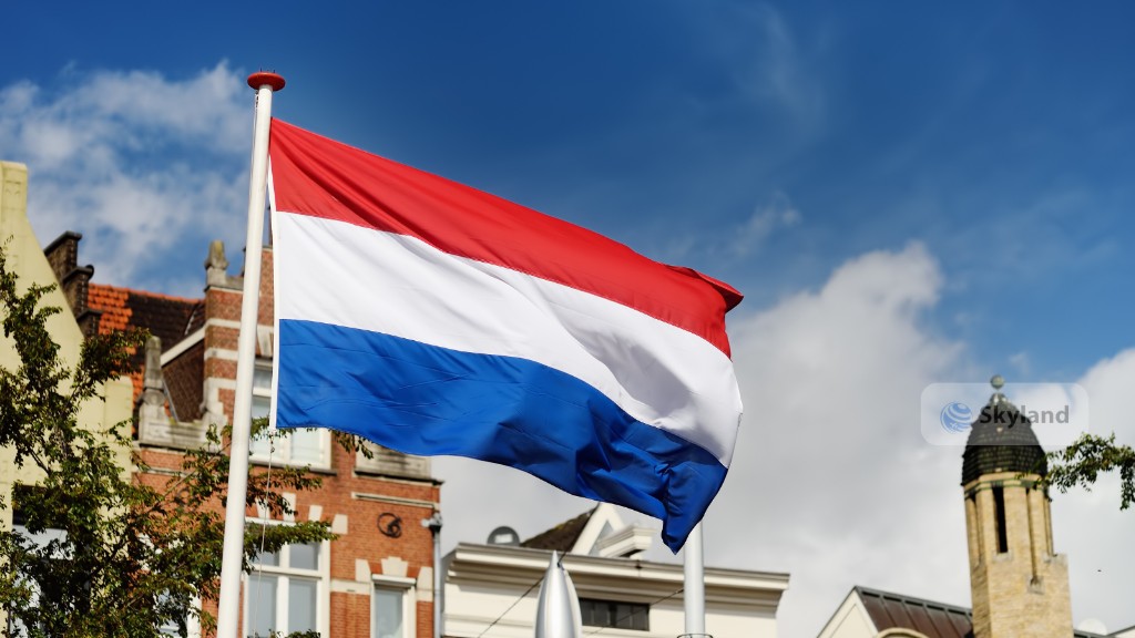 Dutch flag waving above a city street in the Netherlands