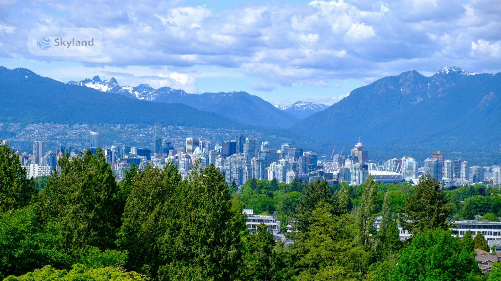 Vancouver city skyline with forest and snow-capped mountains