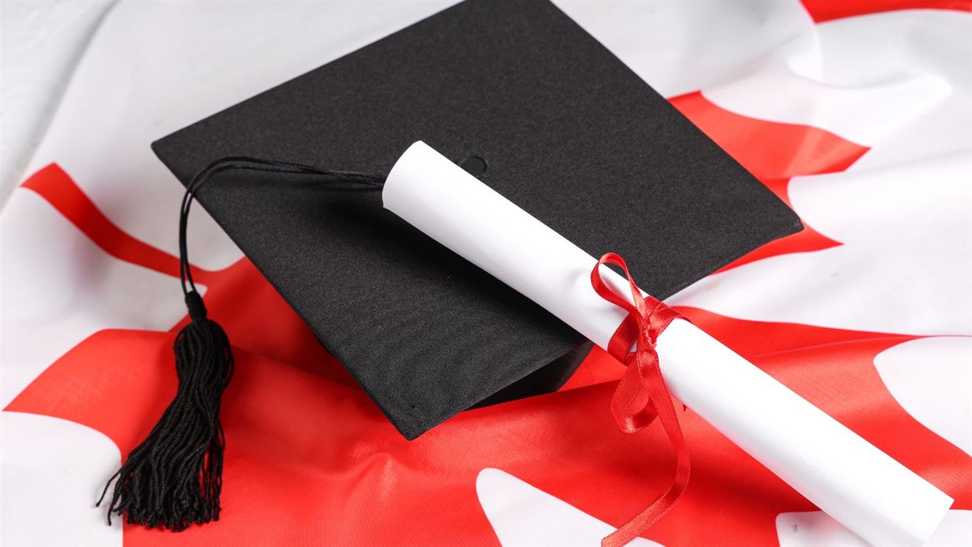 Graduation cap and diploma on the Canadian flag