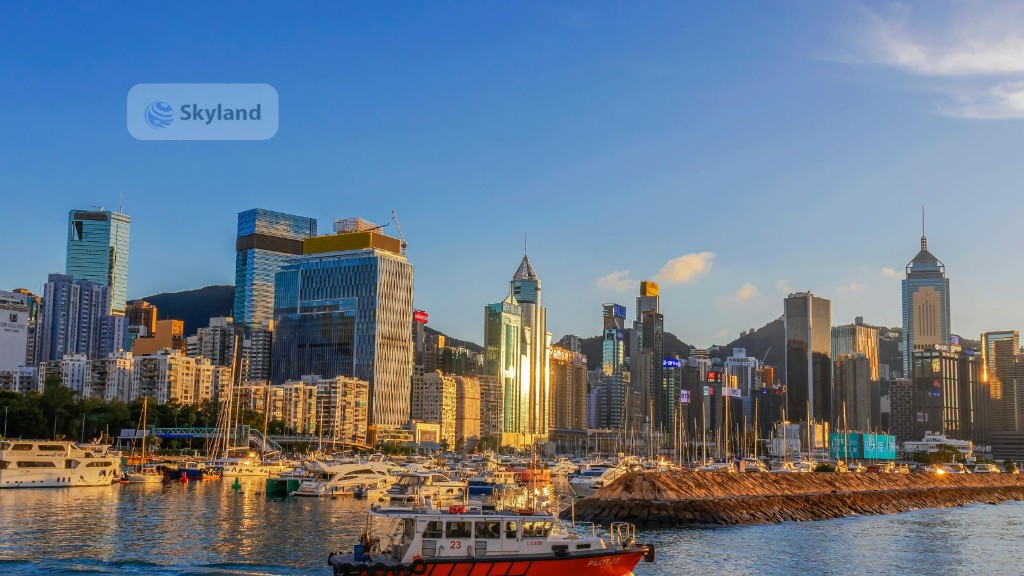 Red-sailed junk boat and Hong Kong skyline on Victoria Harbour