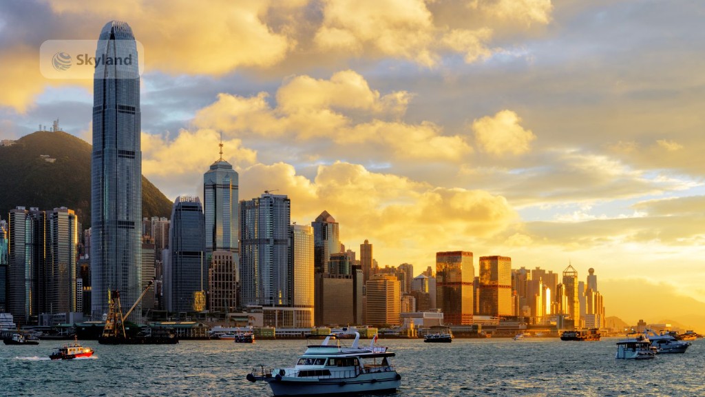Hong Kong harbour at night with a red-sailed junk and Ferris wheel