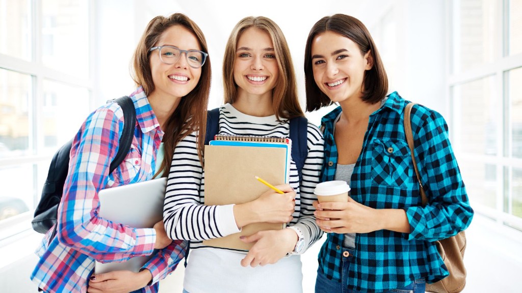 Three students smiling in a university hallway