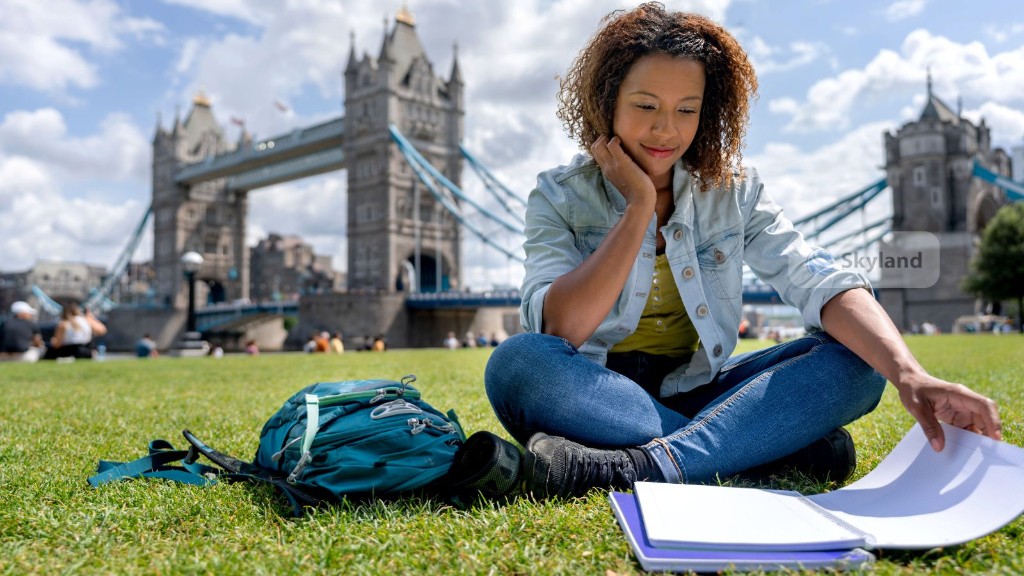 Student studying on the grass with Tower Bridge in the background